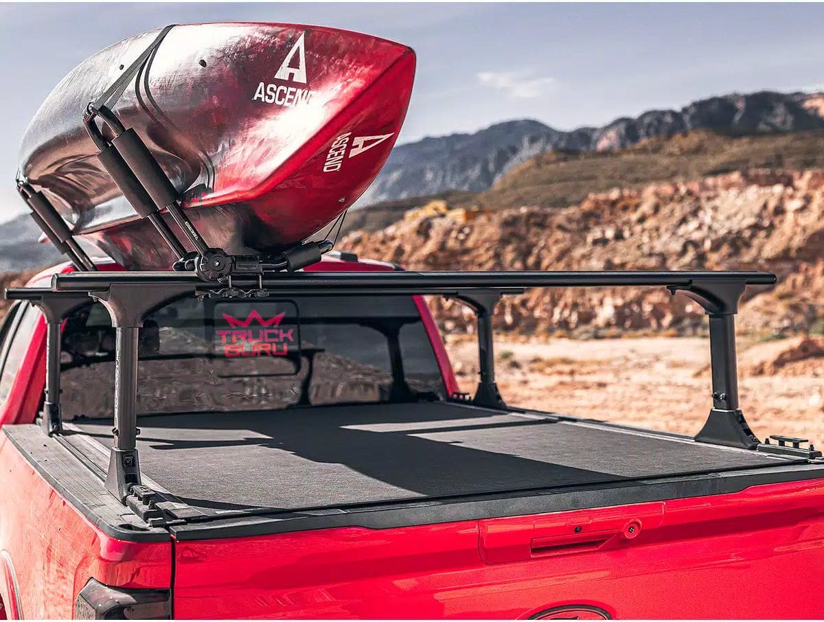 BAK Revolver X4TS bed cover on back of a red truck with a ladder rack and kayak attached to it