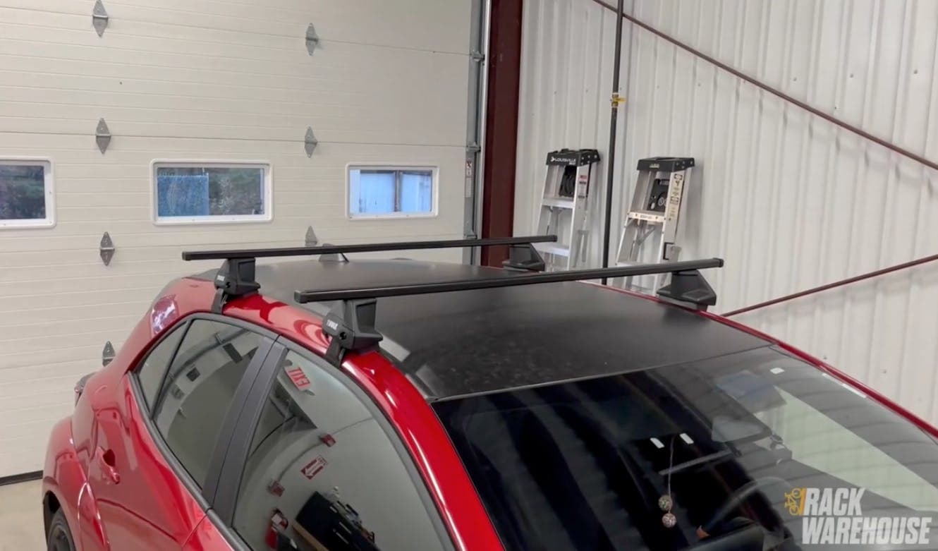 Thule Evo Clamp system with SquareBars installed on a red hatchback